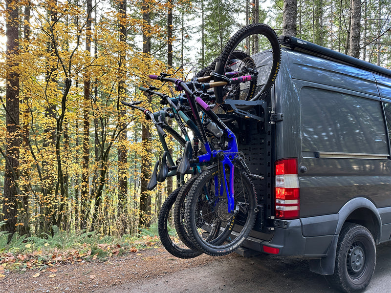 Tokul Racks Van with a bike rack carrying multiple bicycles in a forest setting