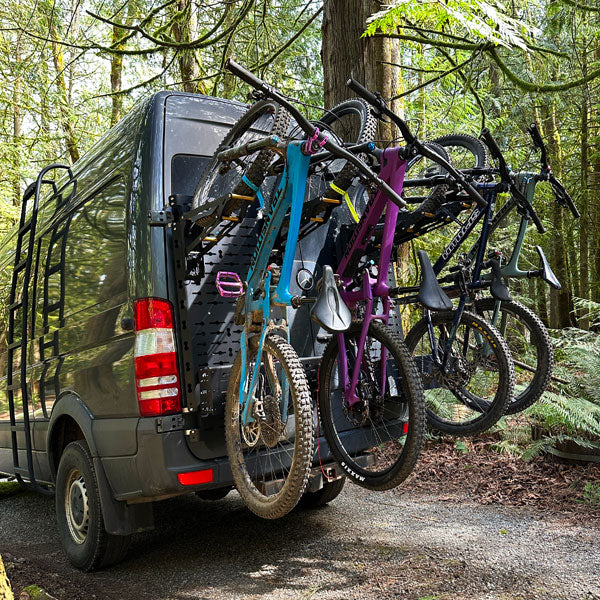 Four bikes mounted on Tokul Racks Panel Bike Rack on van rear door